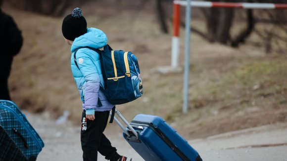 niño refugiado con maletas