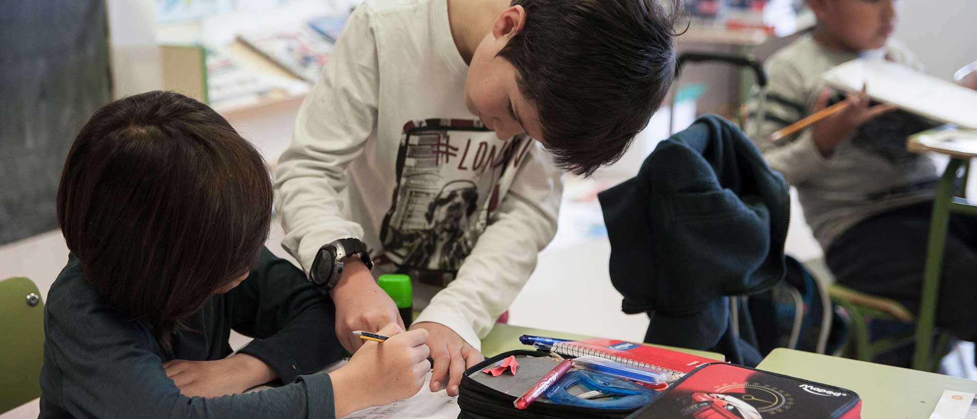 Educación en valores infantil, primaria, segundaría. En la imagén dos niños colaborando en una escuela Educación en valores infantil, primaria, segundaría