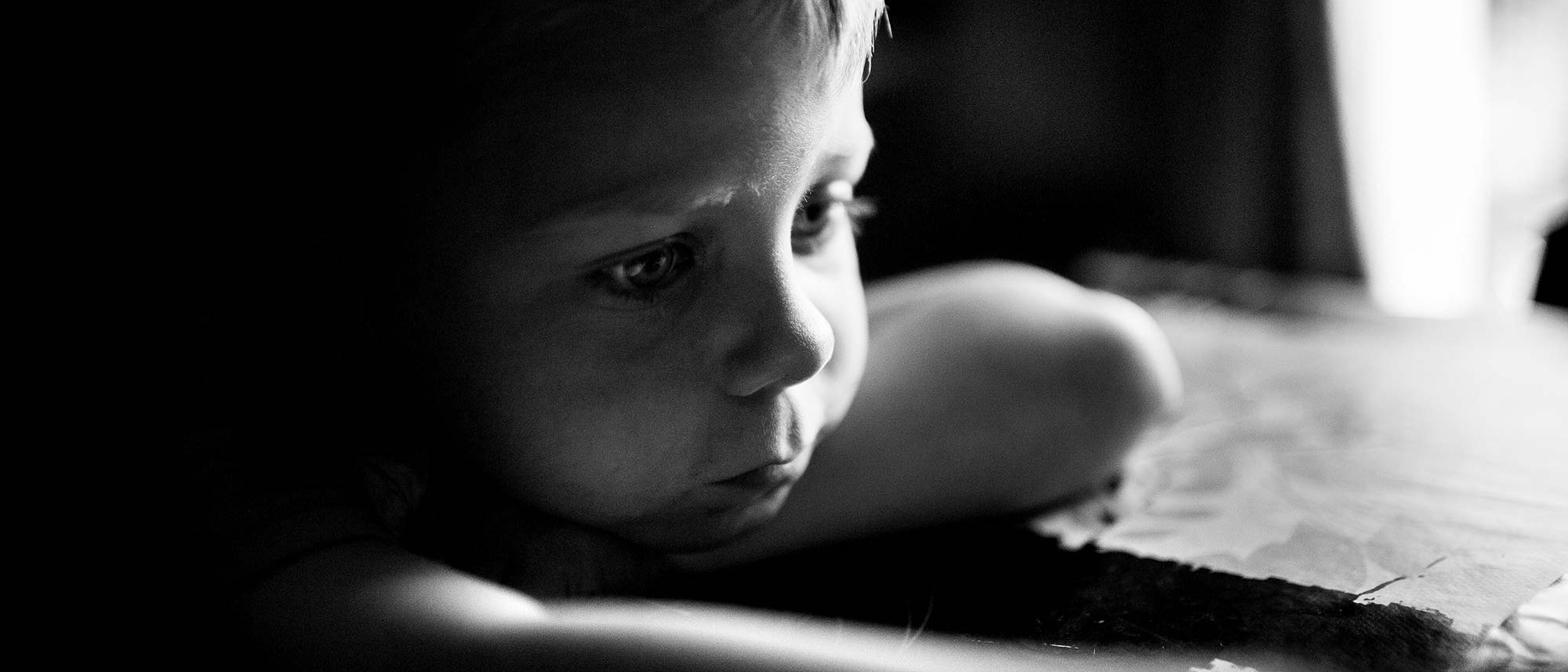 Niño solo apoyado a una mesa Pobreza en España - Niño solo apoyado a una mesa