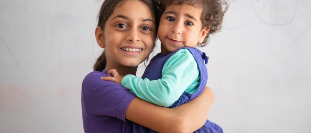 Alizeh con una amiga en el espacio amigable para niñas y niños.