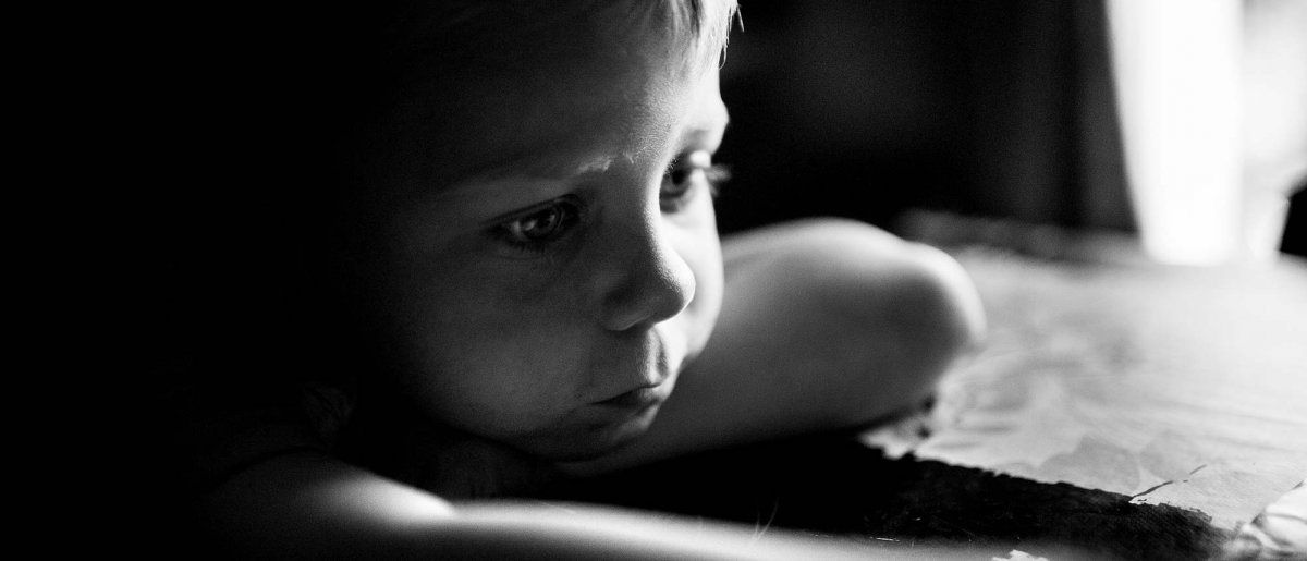 Niño solo apoyado a una mesa Pobreza en España - Niño solo apoyado a una mesa