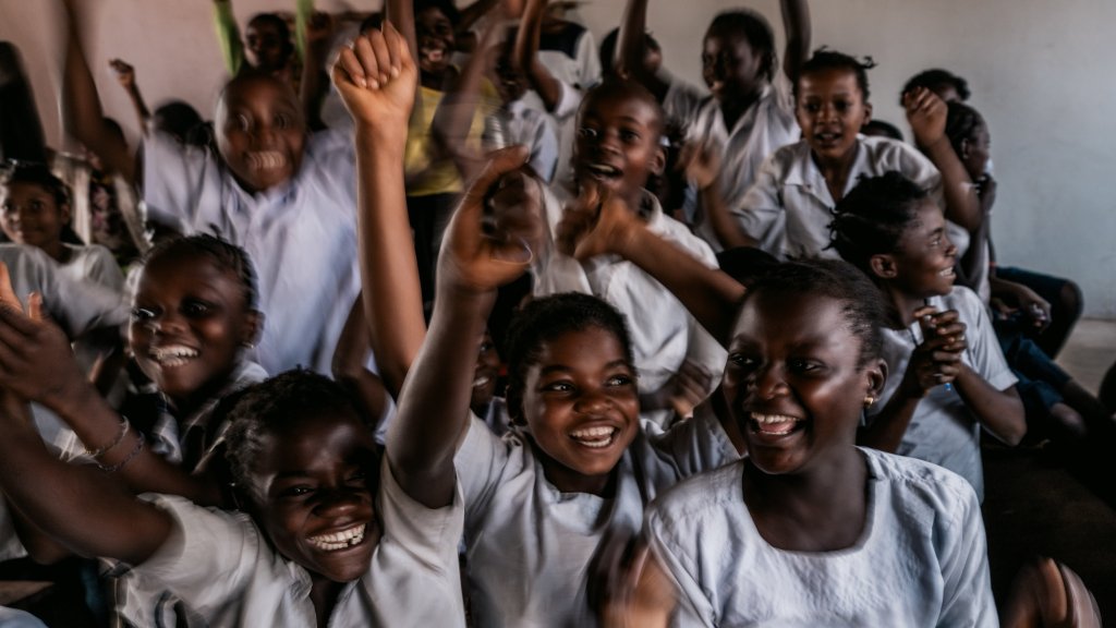 Grupo de niñas y niños sonriendo en aula