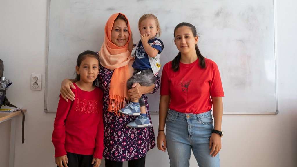 Madiha* con su familia en el espacio amigable para niñas y niños