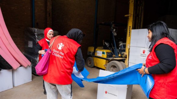 3 trabajadoras de Save the Children preparan un pallet para Gaza