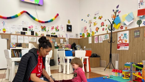 Ucrania - Un espacio seguro de Save the Children con una educadora y una niña en Rumania