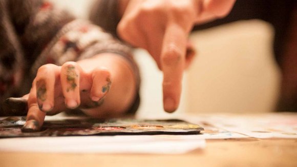 Educación en valores: dos manos pintando. Una de un niño y una de un adulto Educación en valores_niños y niñas