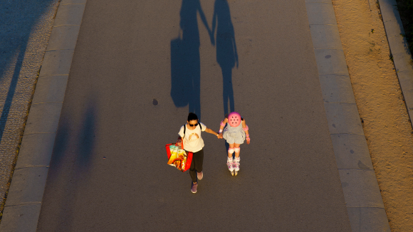 Informe: Infancia en reconstrucción. Una madre con su hija al lado en un parque desde una vista aérea Informe: Infancia en reconstrucción