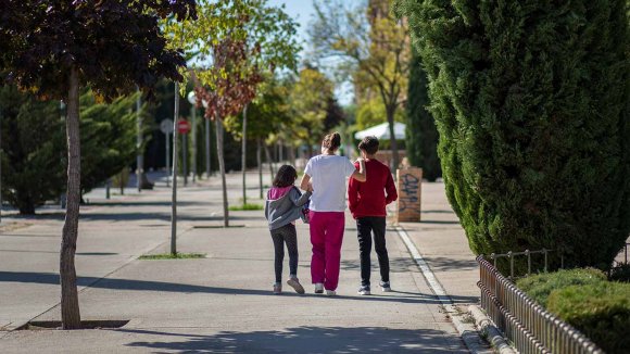 Niños acompañados por su madre en una calle