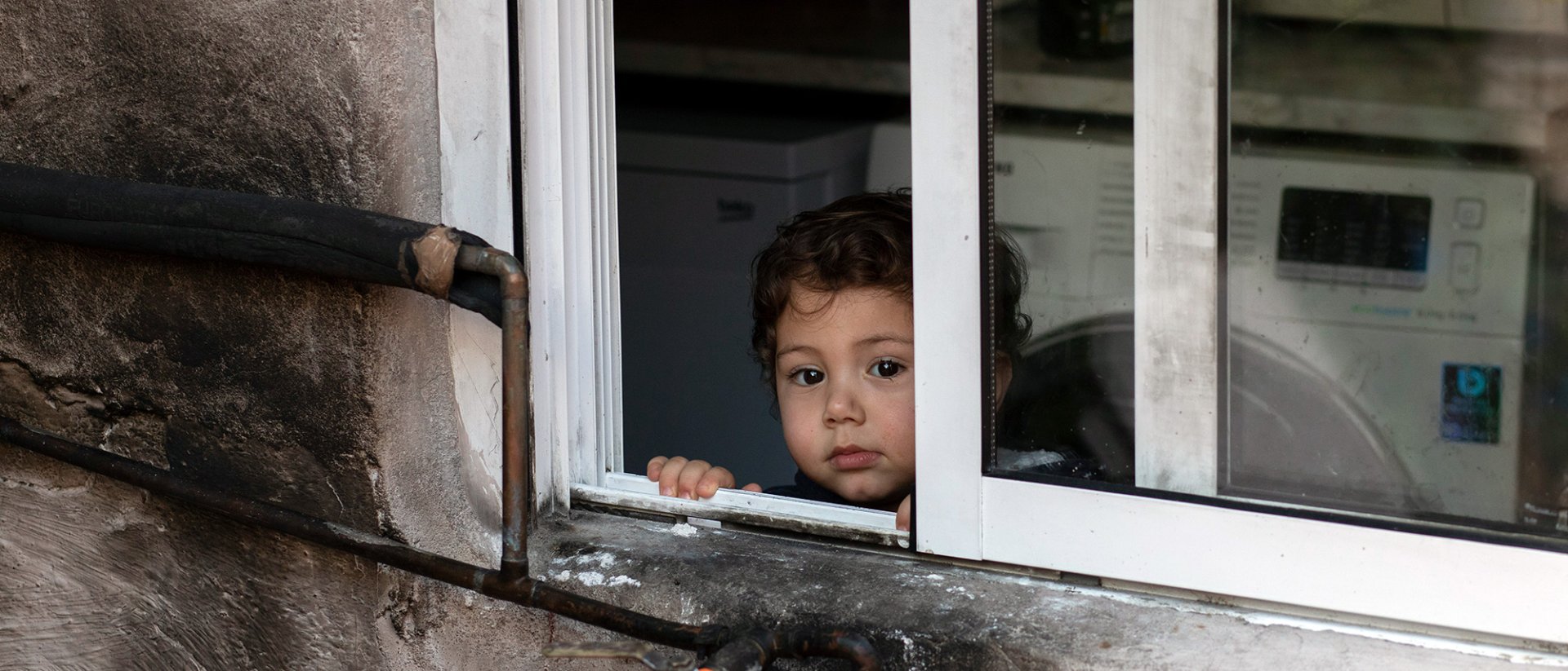 Informe pobreza Europa - Un niño mirando fuera de una ventana Informe pobreza Europa - Un niño mirando fuera de una ventana