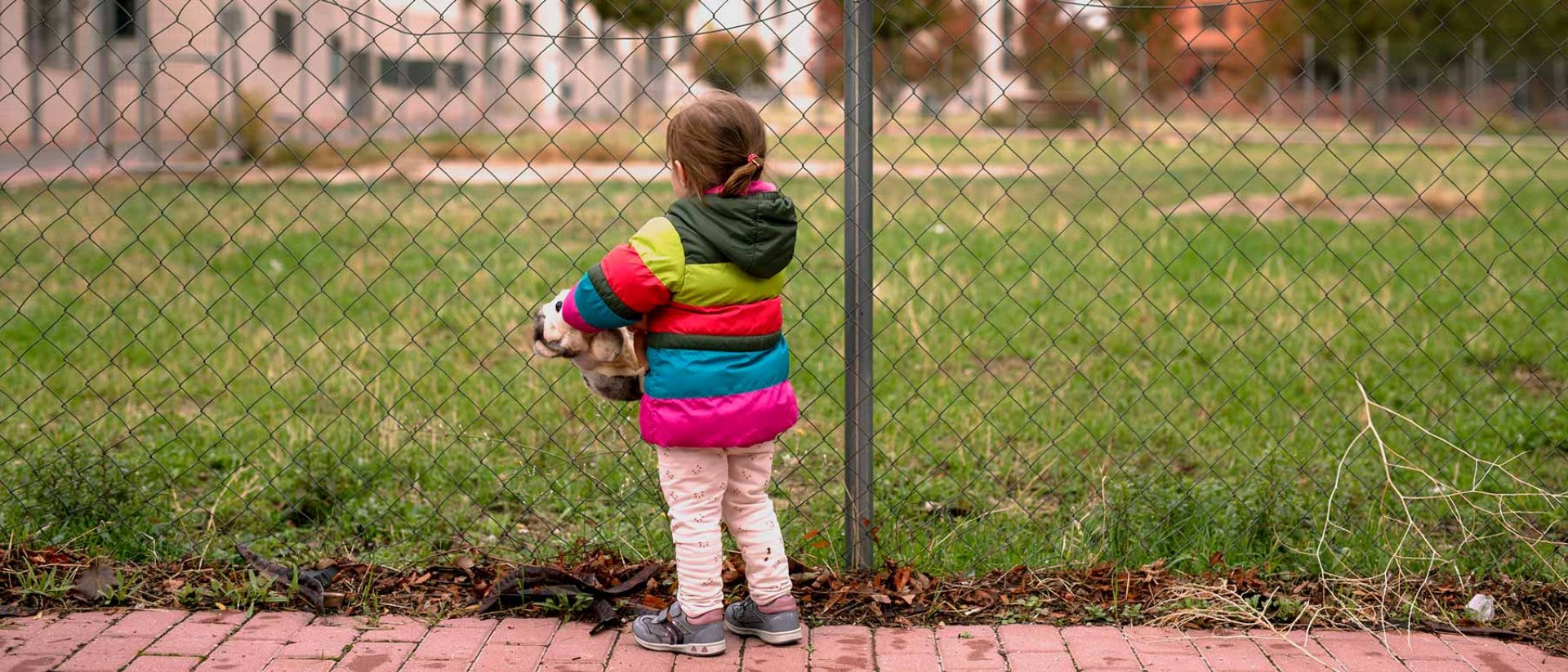 Familias en riesgo de pobreza: una niña sola en un parque Familias en riesgo de pobreza
