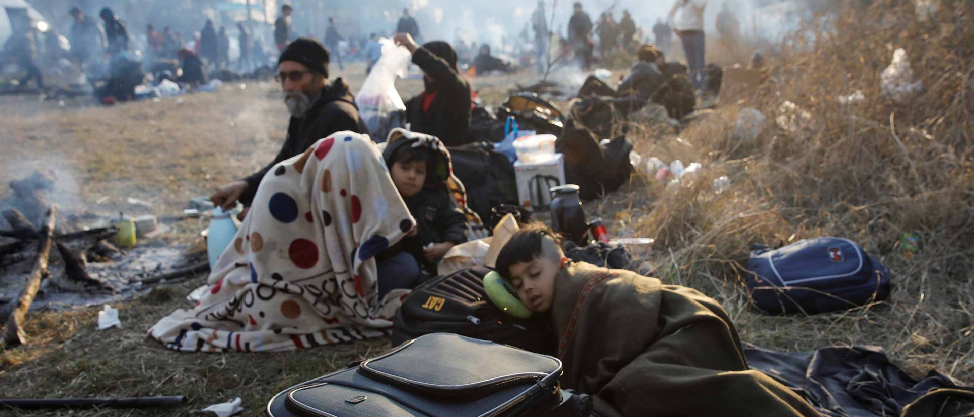 Refugiados sirios al confín con Grecia en un campamento improvisado. En primer plano un niño duerme en el campamento 