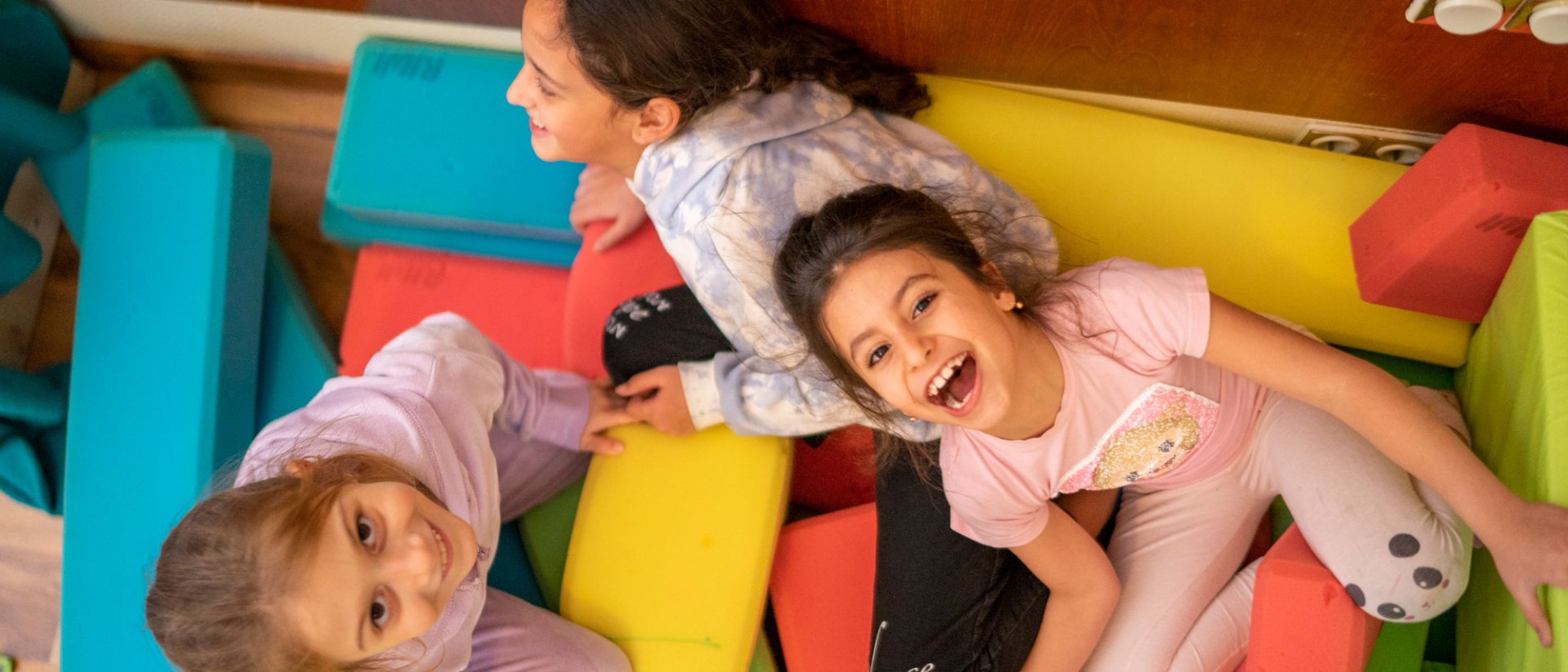 Quiénes somos - Save the Children - 3 niñas que atendemos ríen en uno de nuestros espacios seguros