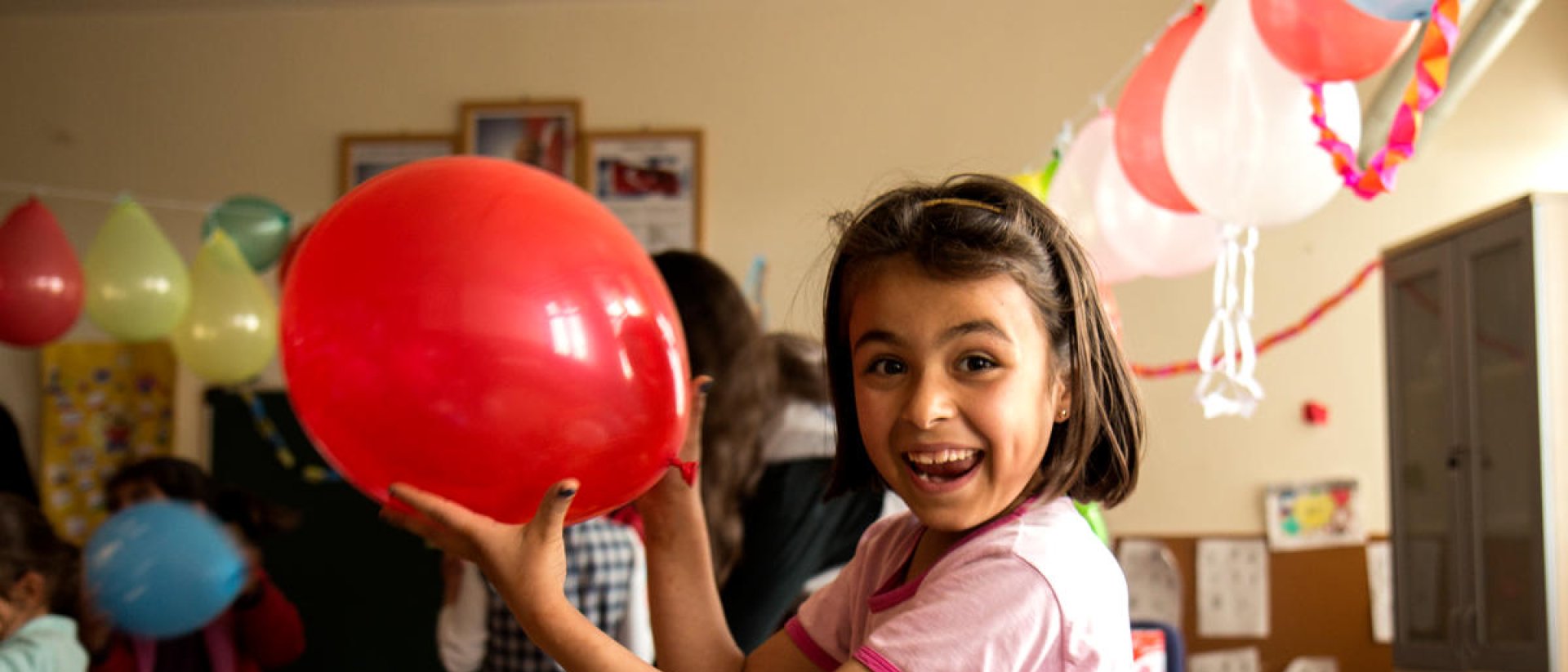 Niña con globo en una clase Niña con globo en una clase