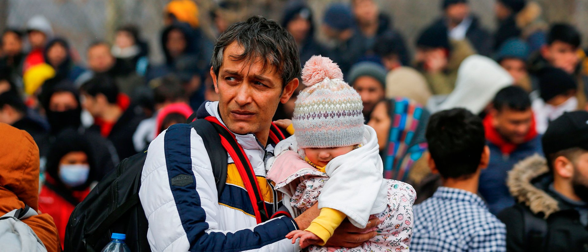 Padre refugiado con su bebé en la frontera Padre refugiado con su bebé en la frontera