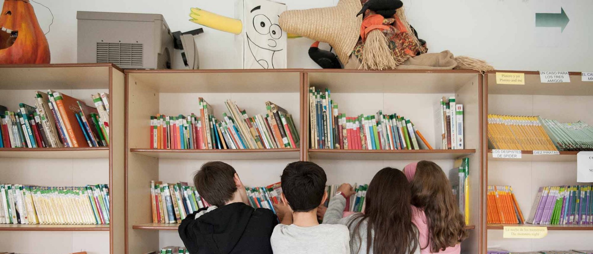 Vuelta al cole en España - Niños delante de una estantería llena de libros Vuelta al cole en España