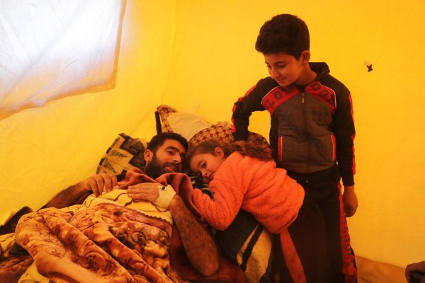 Dina y Ahmad con su padre Lutfi, que se recupera de sus heridas. ©Khalil Ashawi/Save the Children.