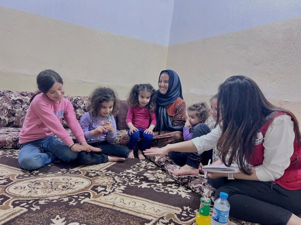 Manar y sus hijos con una trabajadora social de Save the Children en su casa de Duhok, Iraq. [Nour Said/ Save the Children]