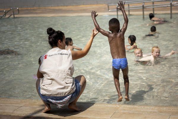 Niños y niñas juegan en una piscina durante las colonias urbanas de Save the Children.