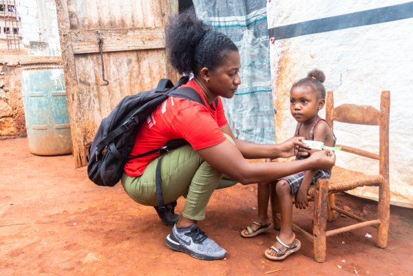 Una asesora del Programa de Alimentación de Lactantes y Niños Pequeños de Save the Children, examina el grado de desnutrición que padece una niña de 3 años. Foto: Reginald Louissaint Junior / Save the Children