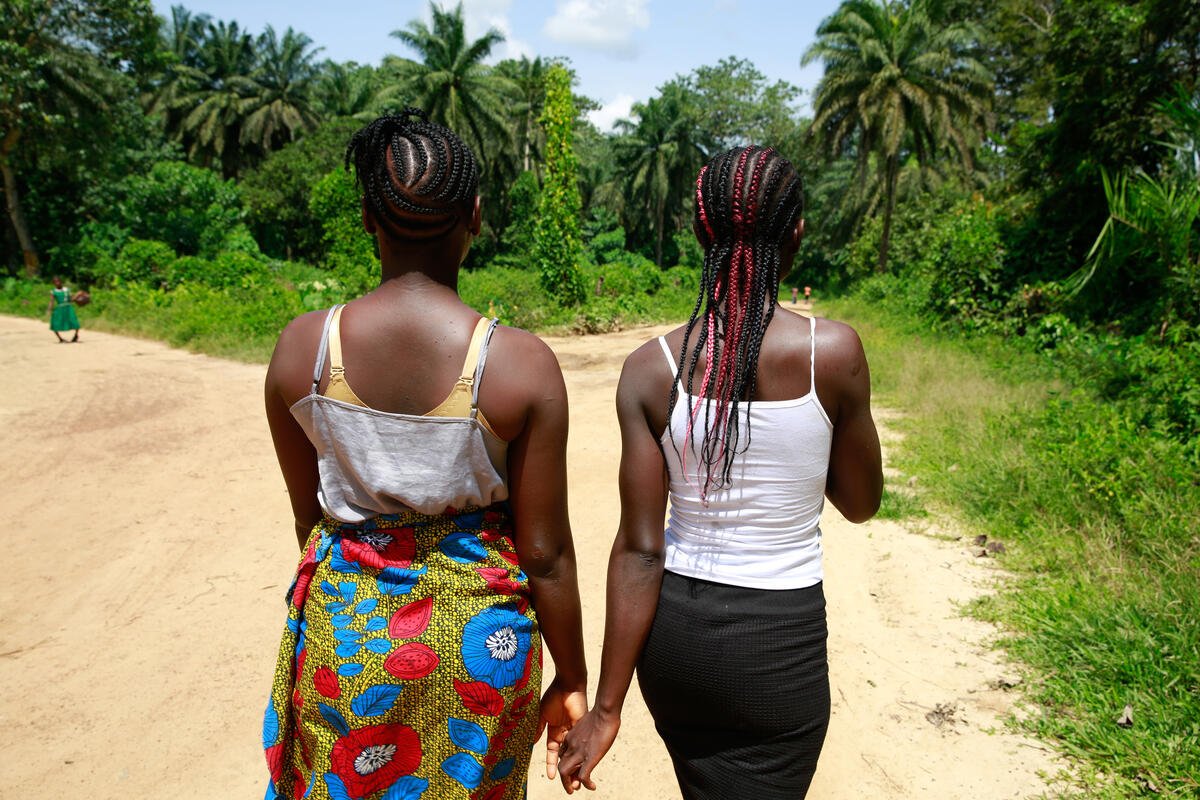 Las primas Kpemeh y Kuji, ambas de 19 años, vuelven a casa cogidas de la mano en Kailahun (Sierra Leona). ©Shona Hamilton/SCI