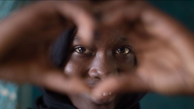 Informe 'Global girlhood report 2024' - Aamira hace un corazón con sus manos