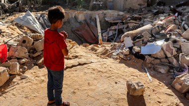 Niño en Gaza delante del cráter de una bomba