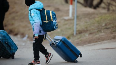 niño refugiado con maletas
